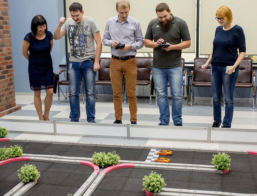 Необычный отдых сотрудников в офисе компании Тензор Ярославль: гонки на игрушечных машинках.